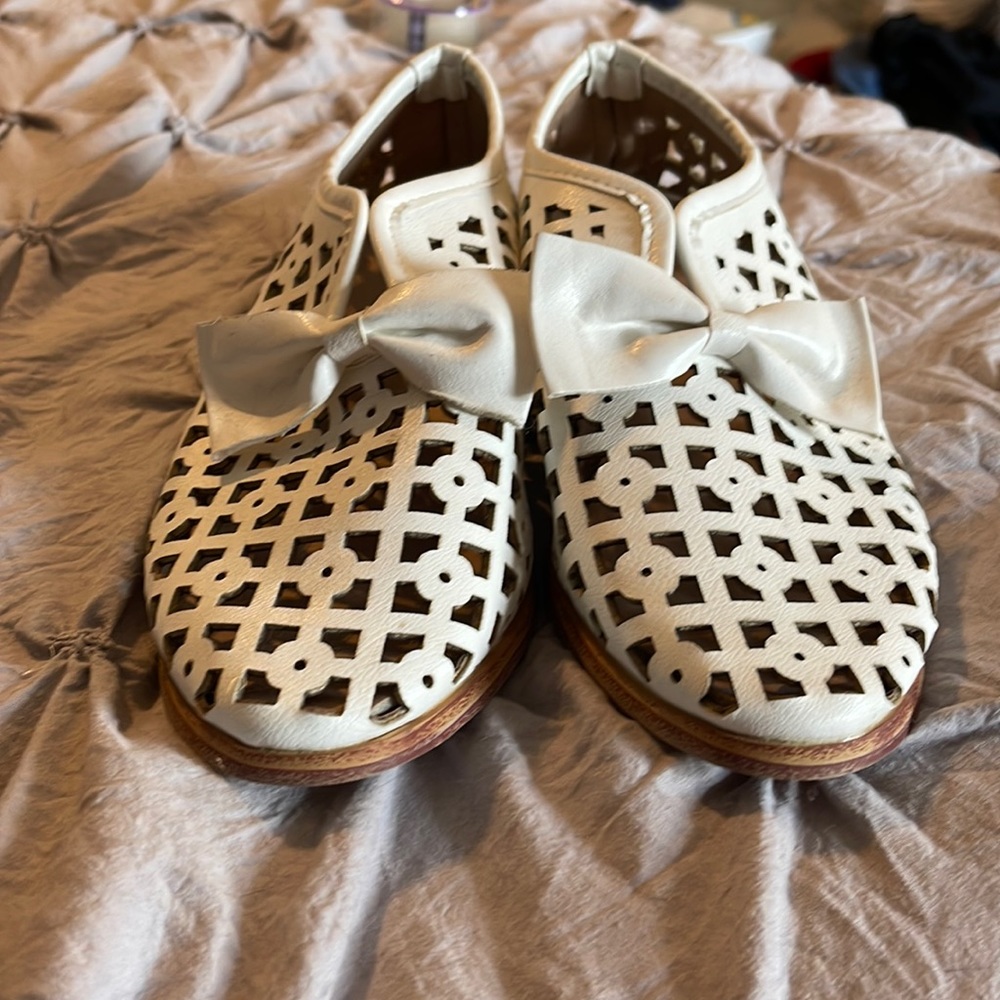White leather shoes with a bow.